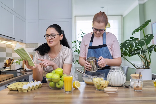 Mãe e filha pré-adolescente cozinhando juntos em casa