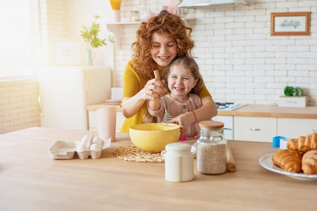 Mãe e filha preparam um bolo juntos na cozinha