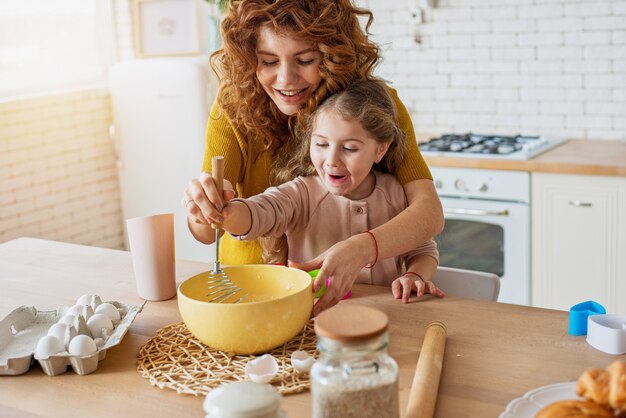 Mãe e filha preparam um bolo juntos na cozinha