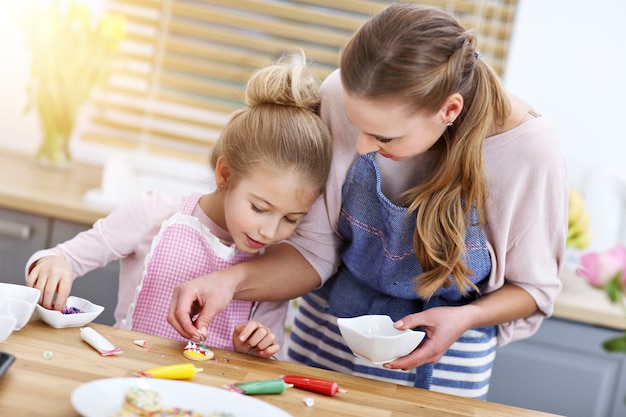 Mãe e filha preparando biscoitos na cozinha