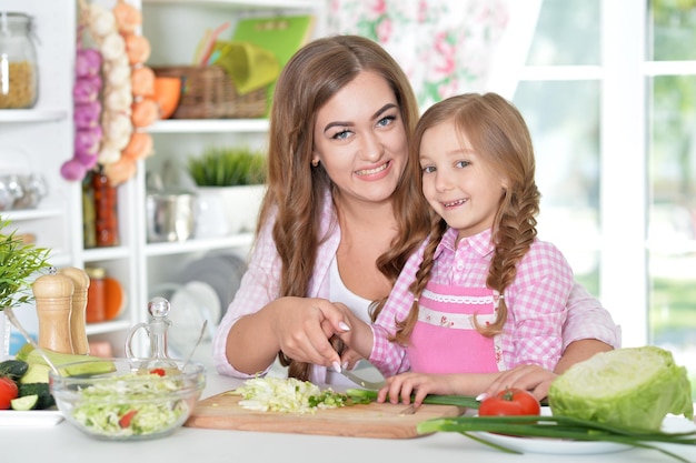 Mãe e filha preparando salada