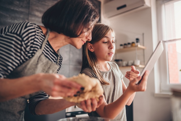 Mãe e filha procurando receita de torta de maçã no tablet