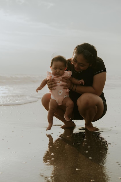 Mãe e filha recém-nascida na praia