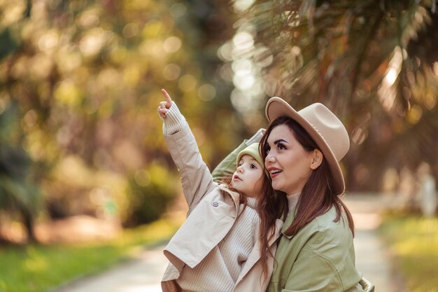 Mãe e filha ruivas estão andando no parque de lazer familiar na cidade