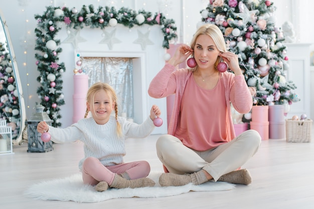 Mãe e filha se divertem na árvore de Natal se preparando para o feriado