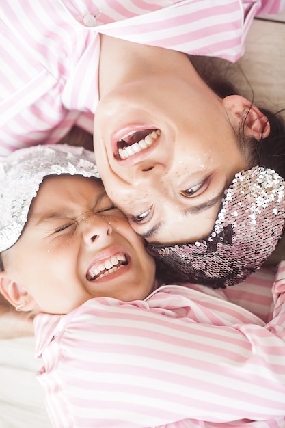 Mãe e filha se divertindo em casa. Meninas dentro de casa.