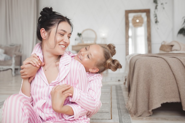 Mãe e filha se divertindo em casa. Meninas dentro de casa.