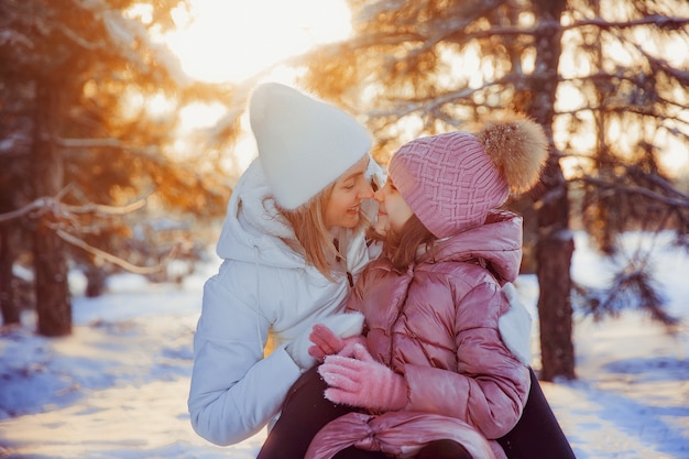 Mãe e filha se divertindo no parque de inverno.