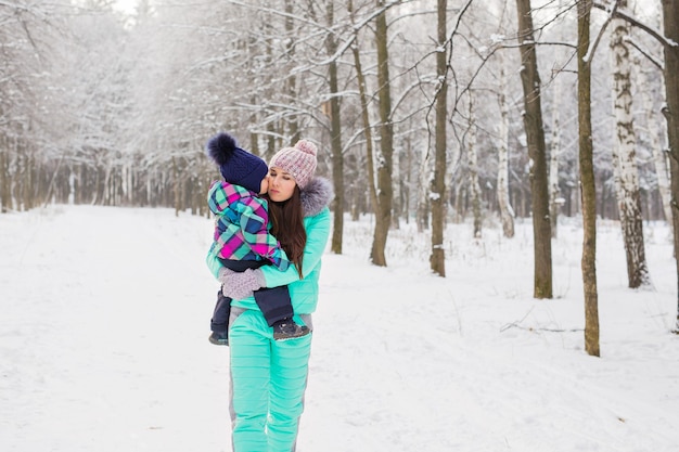 Mãe e filha se divertindo no parque de inverno.