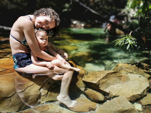 Mãe e filha se refrescar no verão na cachoeira.