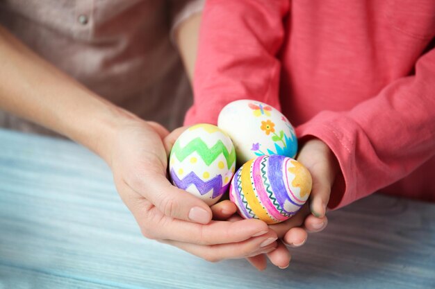 Foto mãe e filha segurando ovos de páscoa decorados