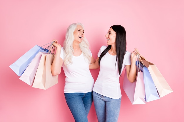 mãe e filha segurando sacolas de compras