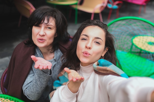 Mãe e filha sentadas juntas em um café