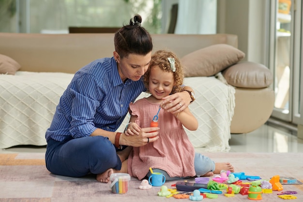 Mãe e filha soprando bolhas de sabão