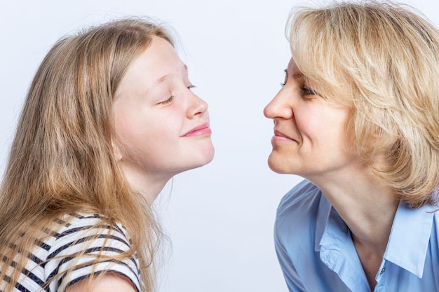 Mãe e filha sorriem e se entreolham Amor e ternura nas relações familiares Fundo claro Fechamento