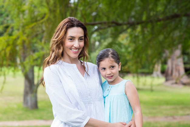 Mãe e filha sorrindo para a câmera