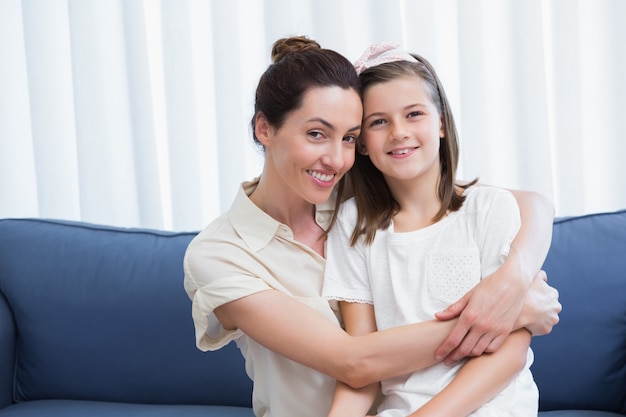 Mãe e filha sorrindo para a câmera