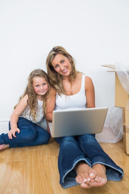 Mãe e filha, usando, laptop, sentando, chão