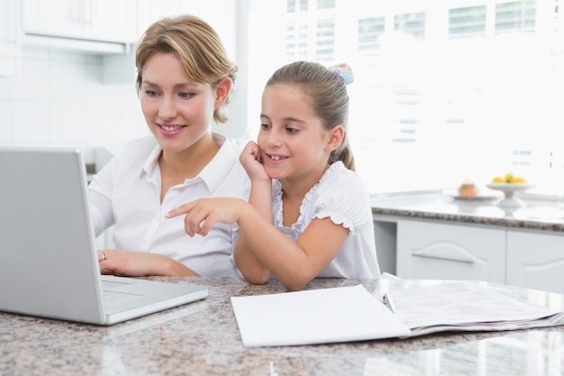 Mãe e filha usando laptop