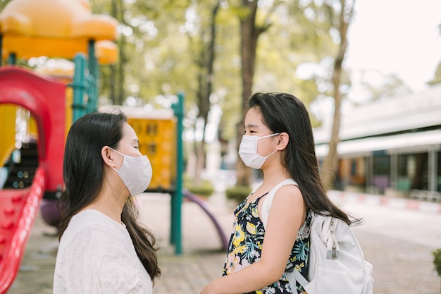 Mãe e filha usando máscara de segurança no rosto para proteção