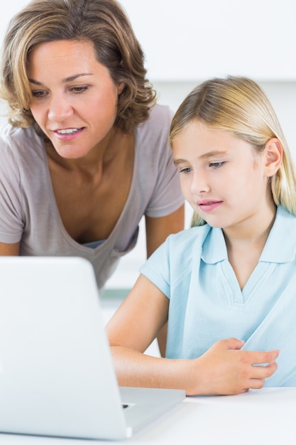 Mãe e filha usando o laptop