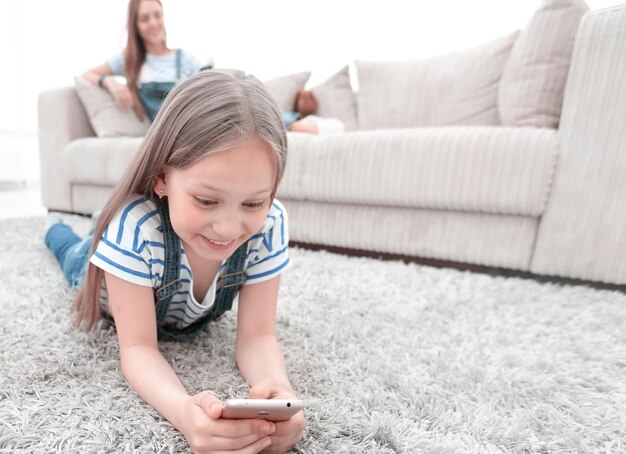 Mãe e filha usando seus smartphones na espaçosa sala de estar