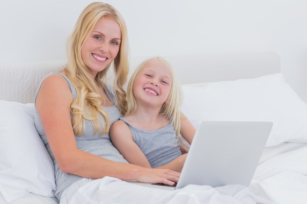 Mãe e filha usando um laptop juntos