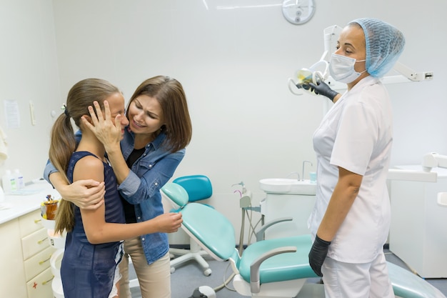 Mãe e filha visitando dentista pediátrico em clínicas dentárias