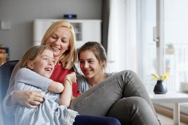 Mãe e filhas felizes a divertir-se em casa.