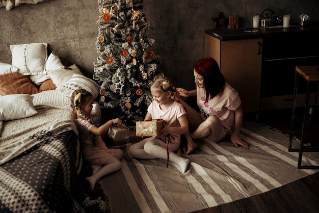 Mãe e filhas perto da árvore de Natal. ano Novo