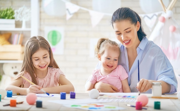 Mãe e filhas pintando juntas