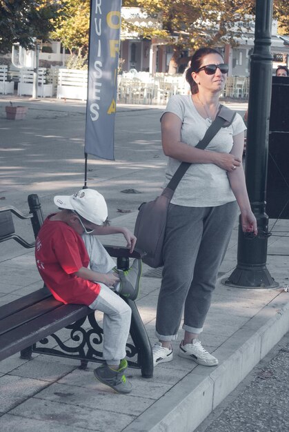 Foto mãe e filho à espera na calçada.