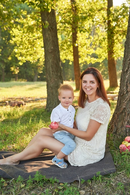 mãe e filho a passear no parque no verão ao pôr do sol