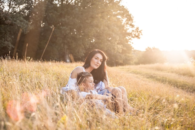 Mãe e filho a relaxar no campo num dia ensolarado.