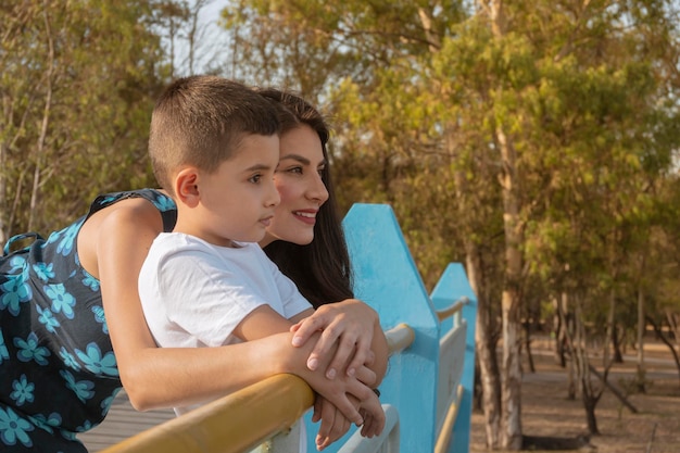 Mãe e filho abraçando juntos ao ar livre ao pôr do sol