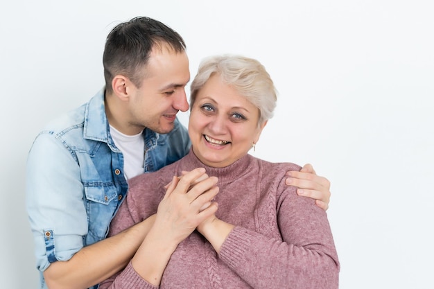 Mãe e filho adulto juntos, filho dando um beijo na mãe.