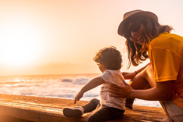 Mãe e filho ao pôr do sol nas piscinas naturais de La Maceta em El Hierro Ilhas Canárias Sentado olhando para o mar nas férias de verão