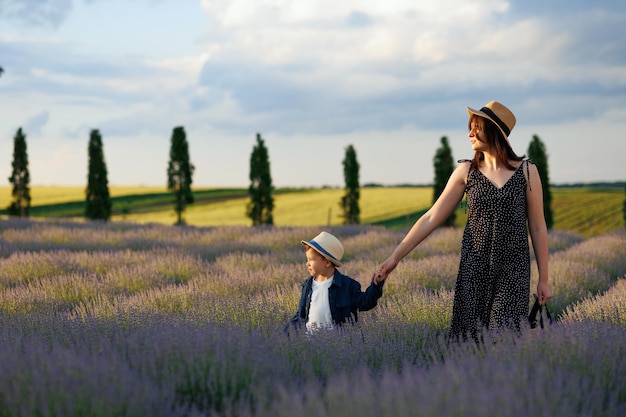 Mãe e filho assistem ao pôr do sol enquanto caminham pelo campo de lavanda