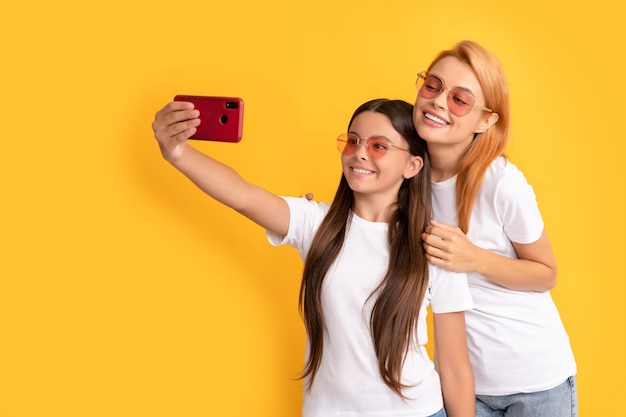 Mãe e filho blogueiros linda mulher e menina tiram selfie com a família selfie do smartphone