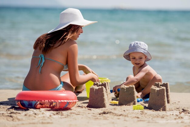 Mãe e filho brincam na praia tropical