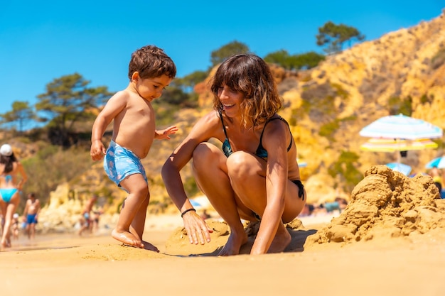 Mãe e filho brincando na praia da Praia do Barranco das Belharucas Albufeira Algarve Portugal