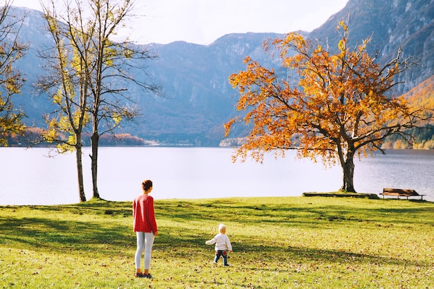 Mãe e filho caminhando ao ar livre. Outono no Lago Bohinj, Eslovênia, Europa. Mulher e seu filho felizes na natureza. A família passa as férias de outono em um belo lago alpino.