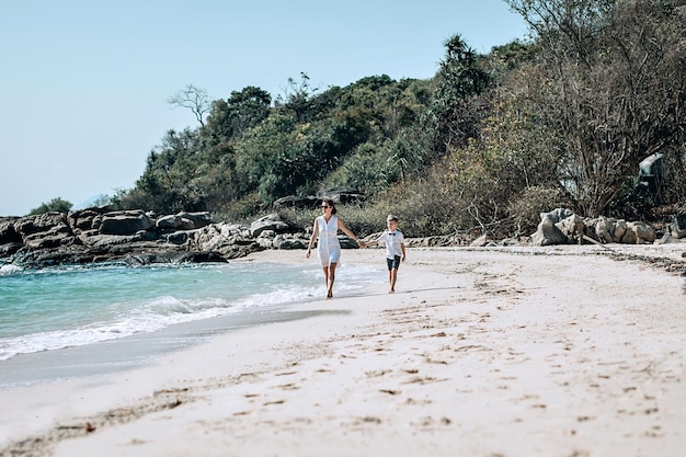 Mãe e filho caminhando ao longo da costa do mar. Mãe segura a mão de seu filho. Conceito de férias de verão no mar. Phuket. Tailândia. Feriado familiar