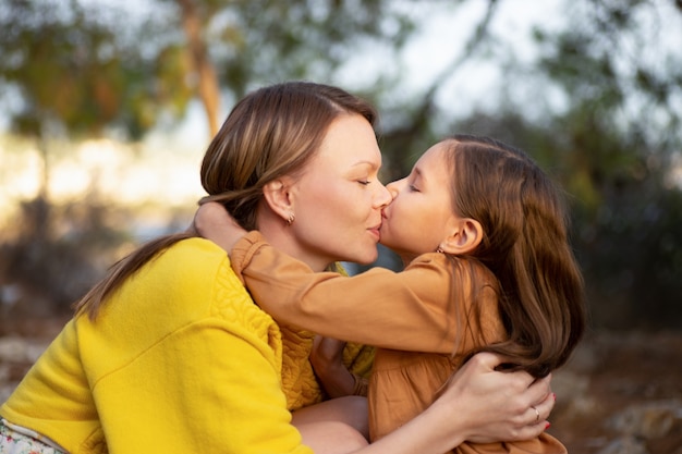 Mãe e filho caminhando e se beijando no parque outono