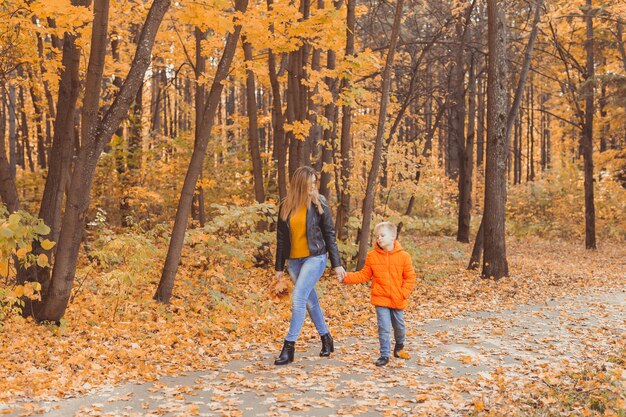Mãe e filho caminhando no parque de outono e curtindo a bela temporada de outono