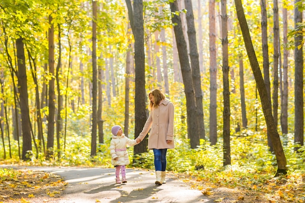 Mãe e filho caminhando no parque outono.