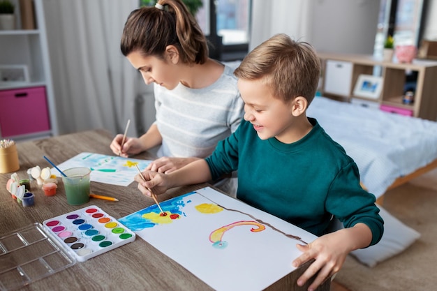 mãe e filho com cores desenhando em casa