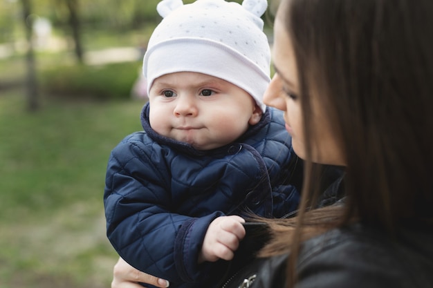 Mãe e filho com uma criança pequena estão caminhando em uma floresta de primavera ou parque