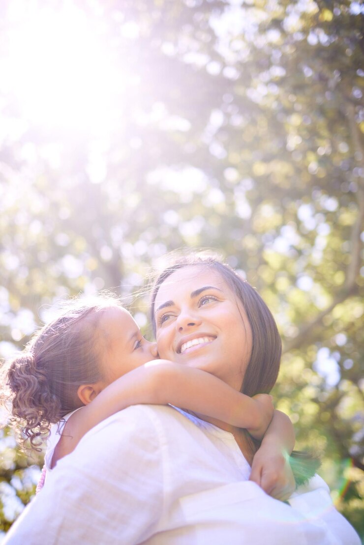 Foto mãe e filho da família se beijam ao ar livre na natureza para diversão de verão com felicidade, amor e carinho mulher ou mãe e criança feliz brincando juntos em um parque para aventura, tempo de qualidade e liberdade
