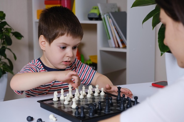 Mãe e filho de 4 anos jogando xadrez.